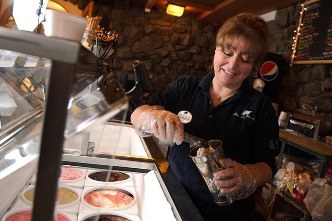 An employee scooping ice cream at Stand 10