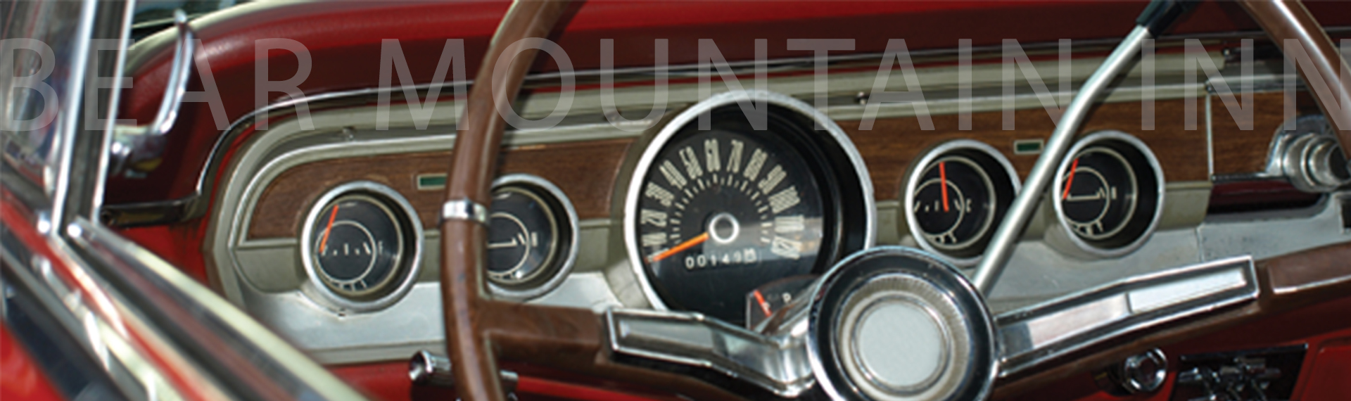 Dashboard of an old car showing the steering wheel, speedometer, and other gauges